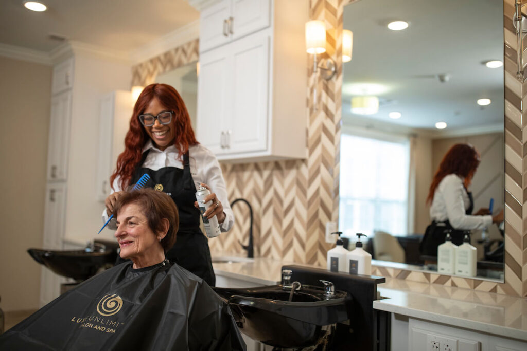 Hairstylist giving older woman a haircut at salon